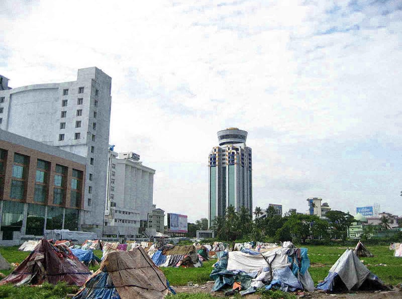 Homeless people's tents contrast with skyscrapers, showing a severe pathology in our culture