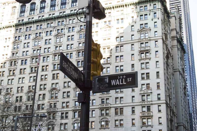 A street sign for Wall Street which represents the free economy, an important topic for Catholic economics