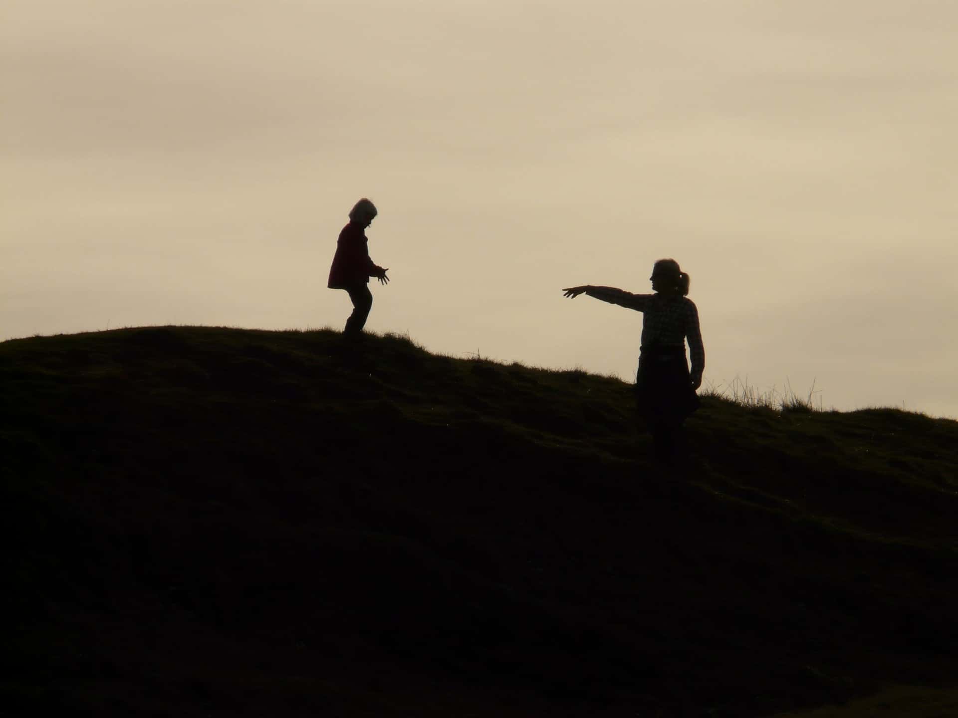 A mother and child silhouetted on a hillside symbolize the human environment