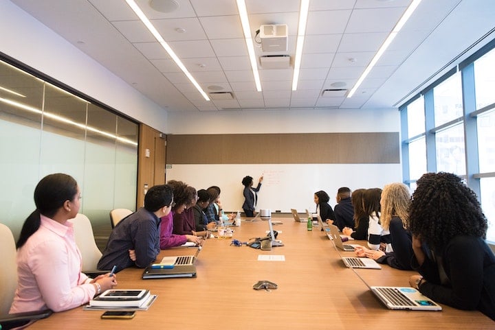 Company employees gather for a business meeting in a conference room.